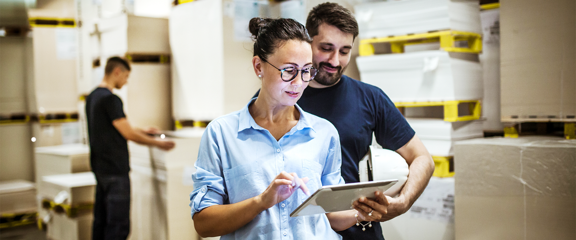 Mitarbeitende eines Großhandels nutzen ein ERP-System bei ihrer Arbeit im Lager