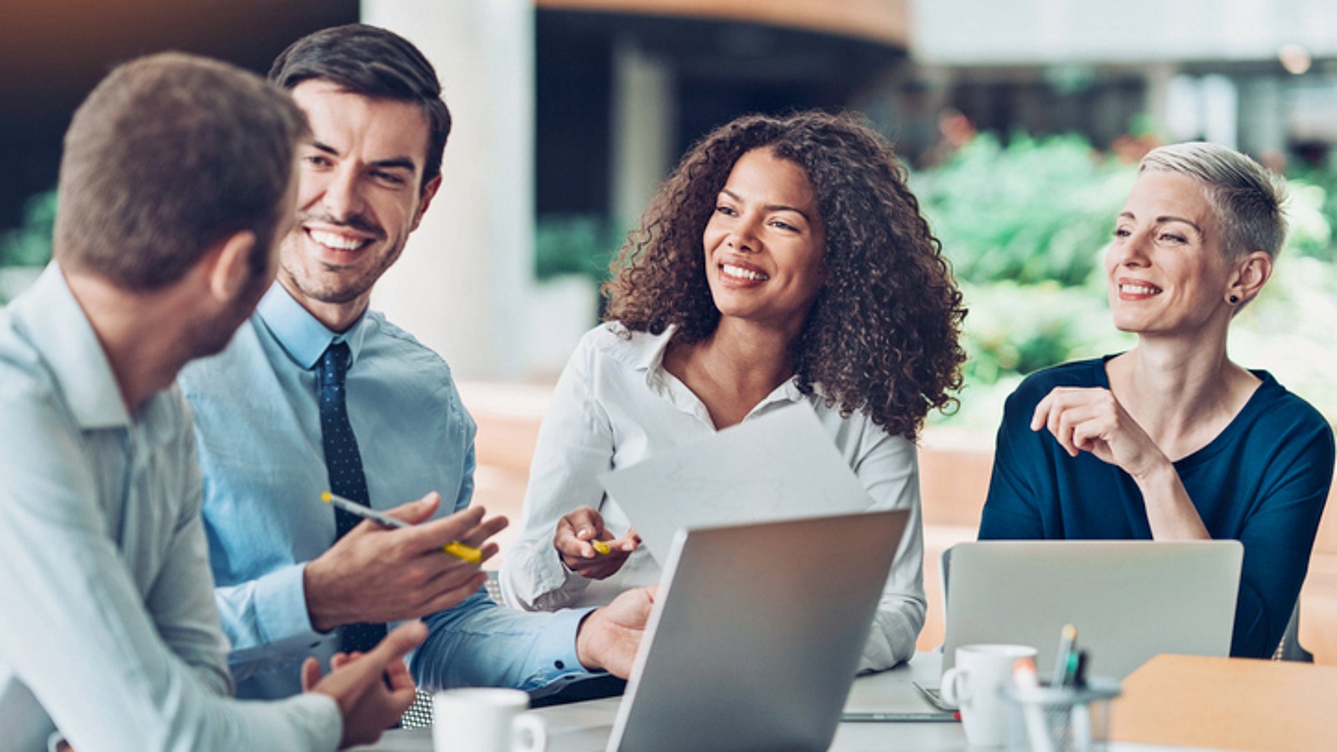KI in Business Central: Ein Team freut sich während eines Meetings über die Arbeitserleichterung