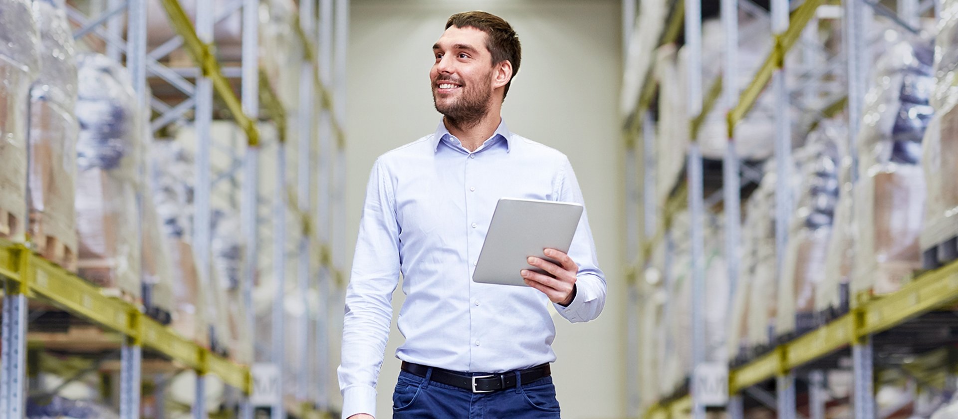 Mitarbeiter geht durch das Lager. Er nutzt Business Central und KatarGo für die Verwaltung.