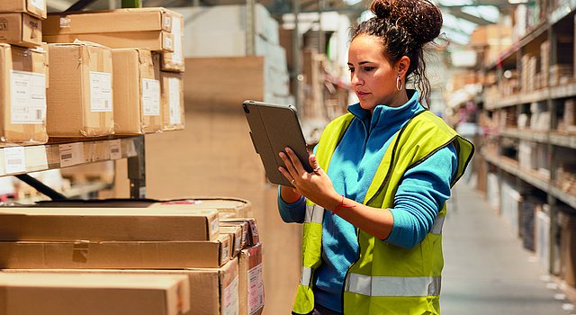 Mitarbeiterin bei der Bestandsaufnahme im Lager nutzt ERP-Software für den Versandhandel