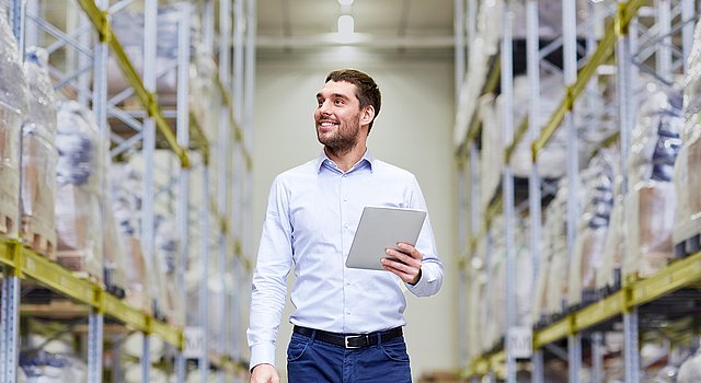 Mitarbeitender verschafft sich im Lager einen Überblick