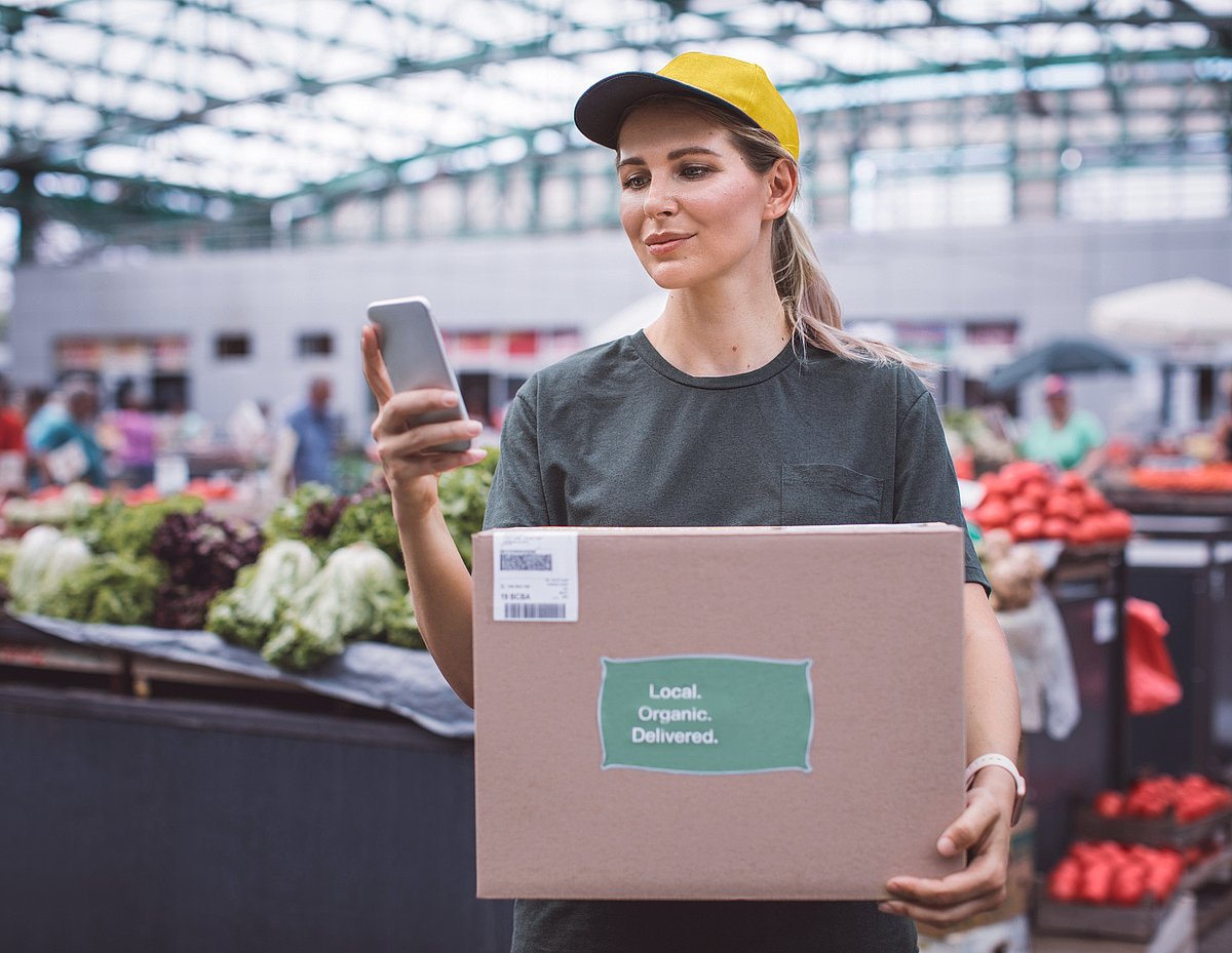 Mitarbeiterin im Fruchtgroßhandel erfasst Obst und Gemüse mit mobilem Endgerät
