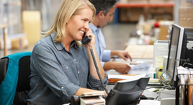 Mitarbeitende im Kundenservice telefoniert und nutzt dabei KatarGo